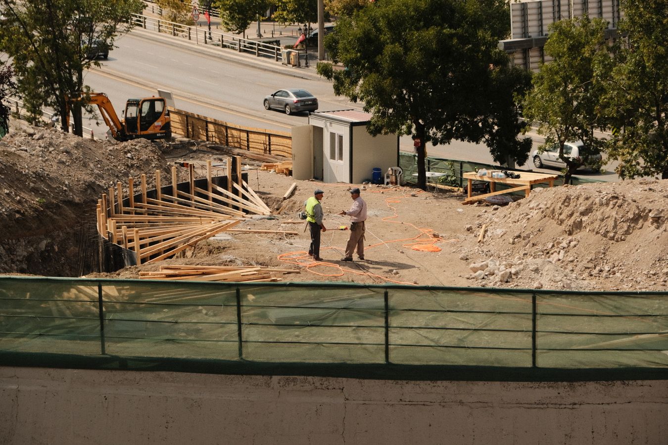 Profissionais conversam em um canteiro de obras em atividade